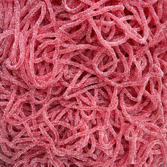 A close-up pile of pink sour candy strips coated in sugar, filling the entire frame.