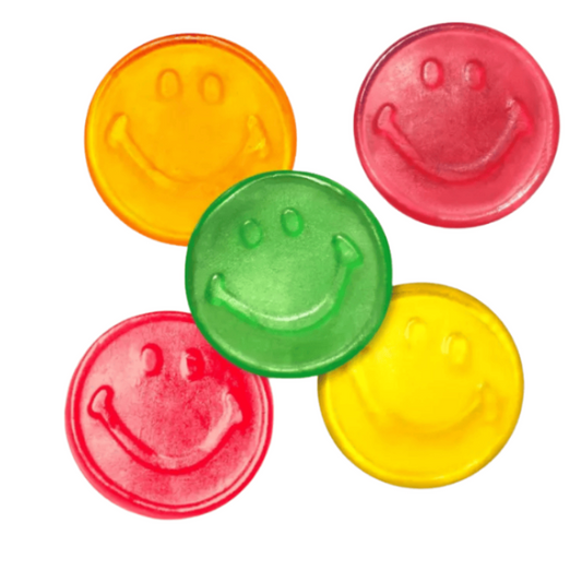 Five round smiley face candy in yellow, green, and red, arranged on a plain white background.